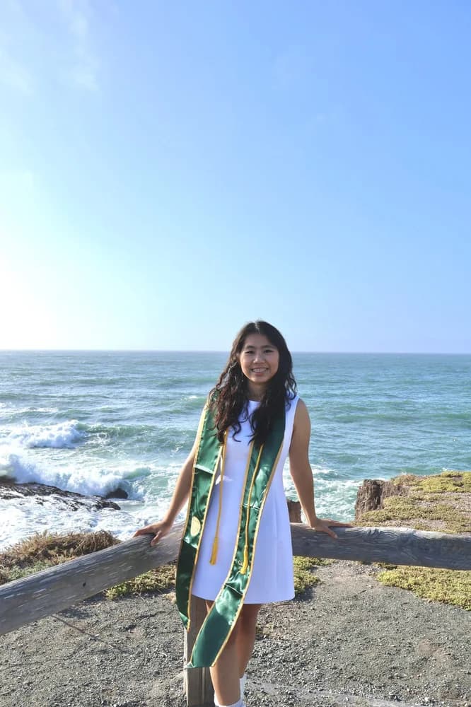 Sue in a white dress in front of the sea